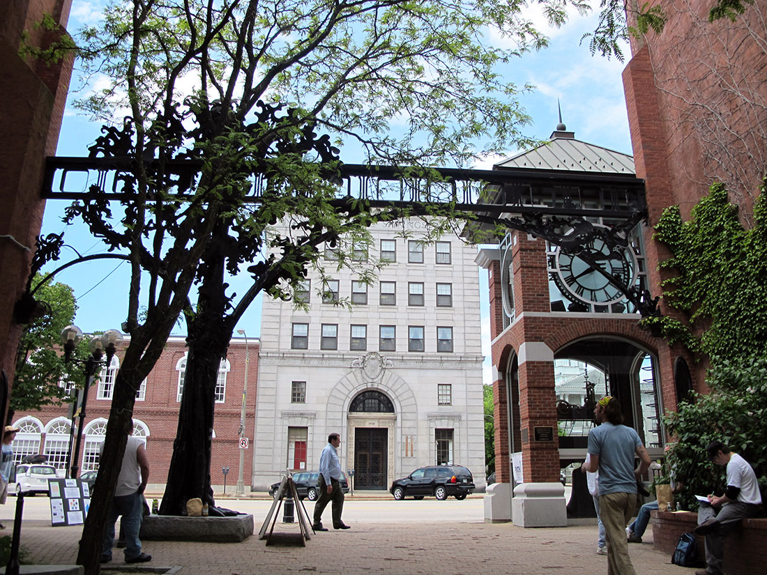 a downtown area with a clock tower and brick buildings