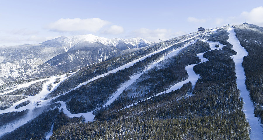 aerial view of a ski area and snow covered mountains