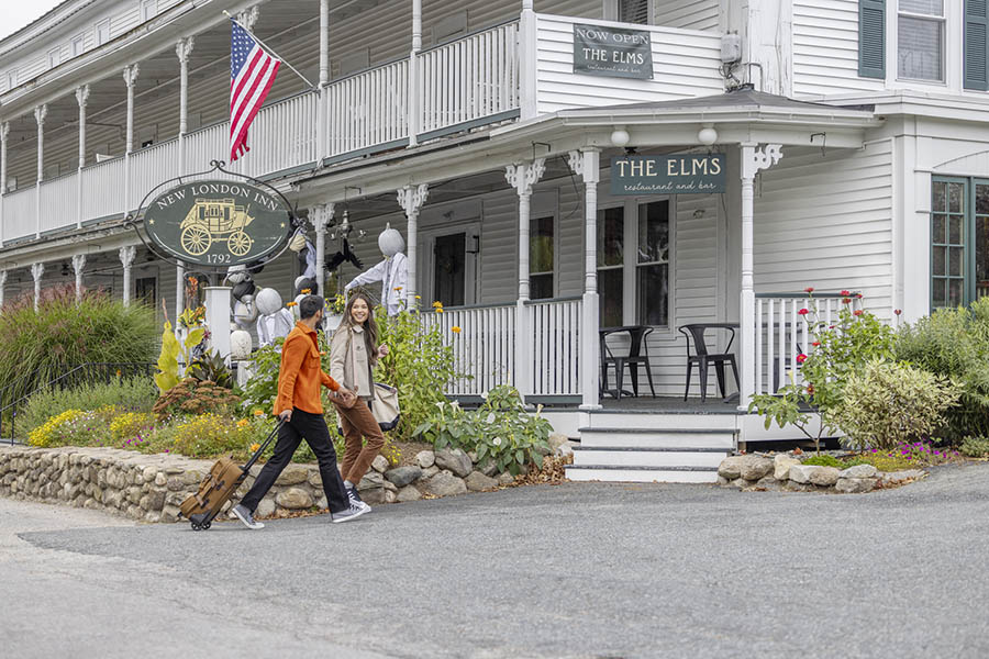 a man and woman with a suitcase entering an inn