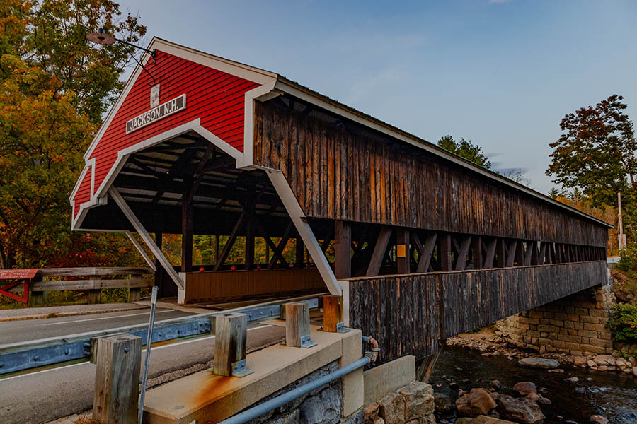 a covered bridge with a red front and wooden sides