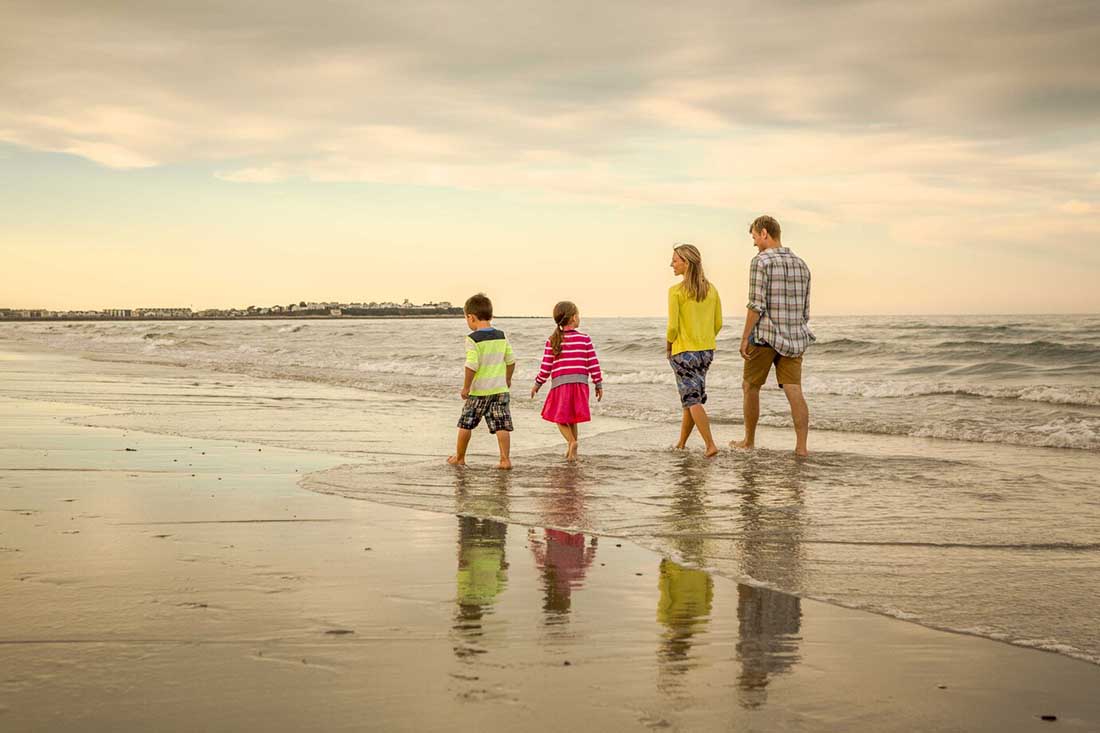 a family on a beach at sunset